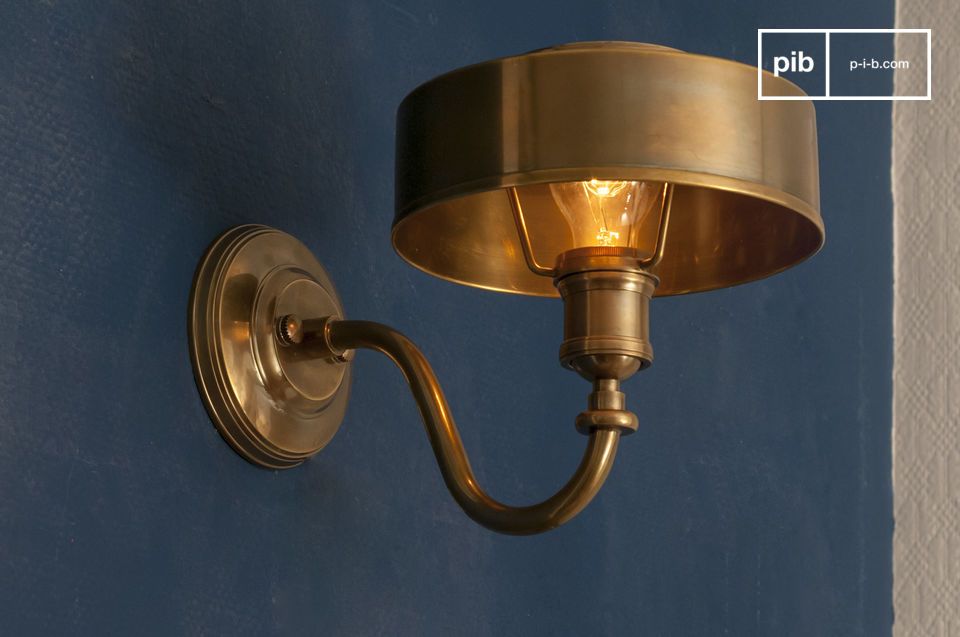 La lampada da parete in ottone color oro ambra porta un tocco di calore e un\'atmosfera morbida al