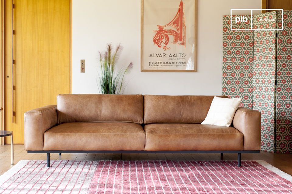 Un divano dal design armonioso, elegantemente sostenuto da una struttura metallica.