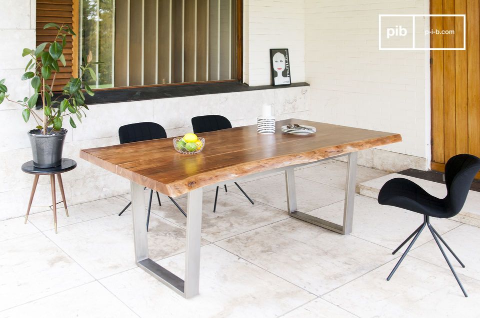Tavolo grande in legno chiaro con base angolare in metallo.