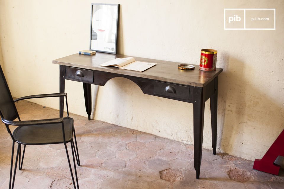 La scrivania combina un piano in palissandro e una base in acciaio.