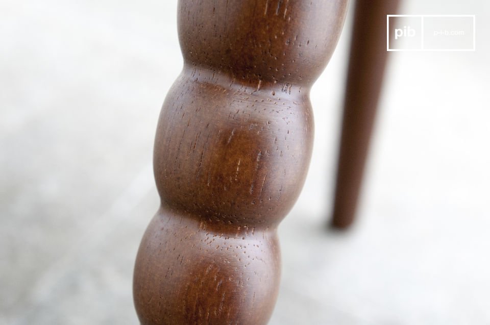 Una delle gambe è tutta rotondità scolpita nel legno.