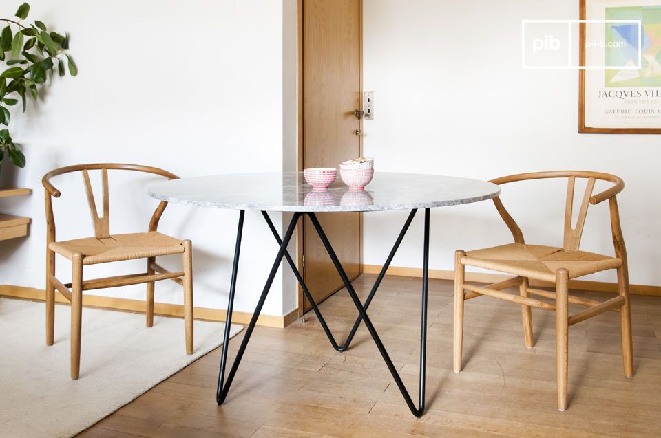 Bellissimo tavolo in marmo e metallo nero con un design semplice e grafico.