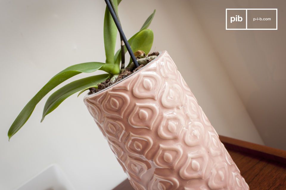 Un vaso in ceramica rosa lavorato in uno stile vintage pieno di delicatezza